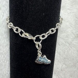 sterling silver charm bracelet featuring a shoe-shaped pendant.